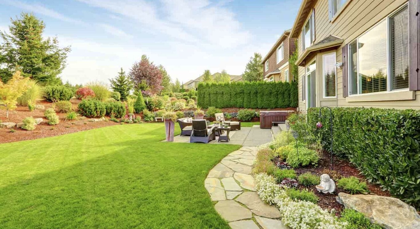 Professional landscaping services in Hoffman Estates, IL showing beautifully designed backyard with patio and lush green lawn